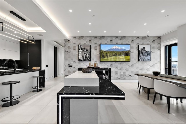 kitchen featuring a kitchen island, recessed lighting, modern cabinets, and an accent wall