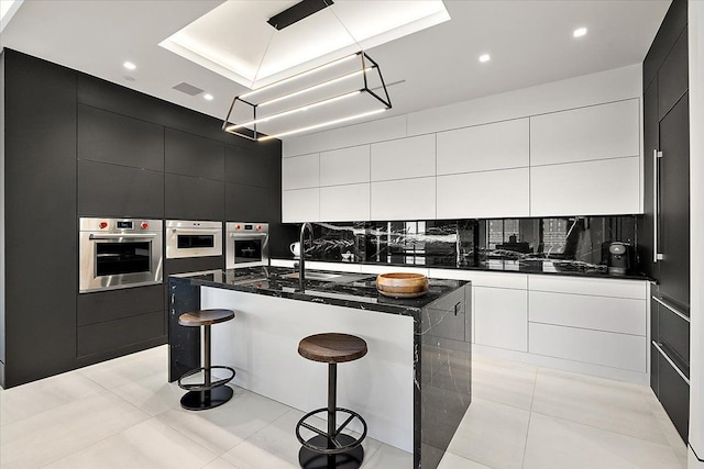 kitchen featuring stainless steel oven, oven, modern cabinets, and dark cabinets