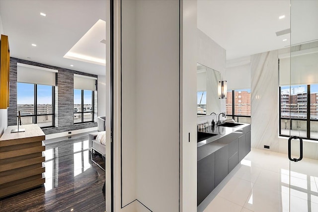 bathroom featuring a sink, a raised ceiling, and recessed lighting