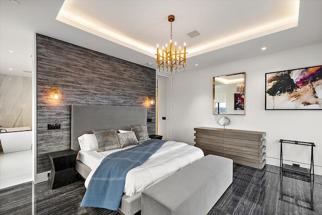 bedroom featuring recessed lighting, a tray ceiling, an inviting chandelier, and an accent wall