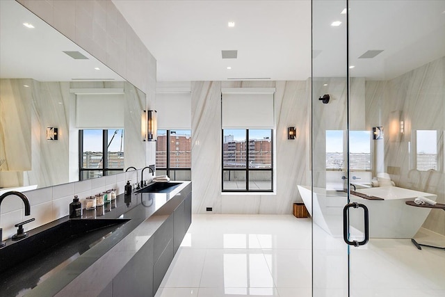 bathroom with recessed lighting, a stall shower, a sink, tile patterned floors, and backsplash