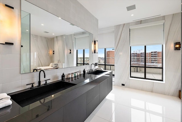 bathroom with a sink, backsplash, double vanity, and tile patterned flooring