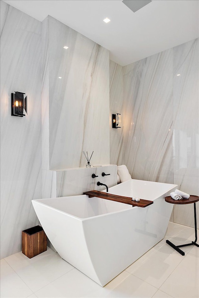 full bath featuring tile patterned floors, a freestanding bath, and tile walls