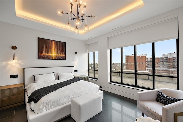 bedroom featuring a raised ceiling and an inviting chandelier