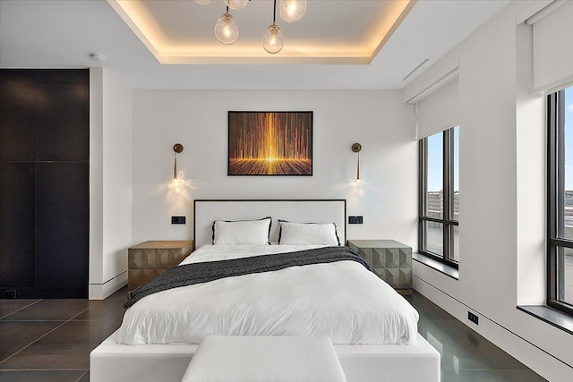 bedroom with baseboards and a raised ceiling