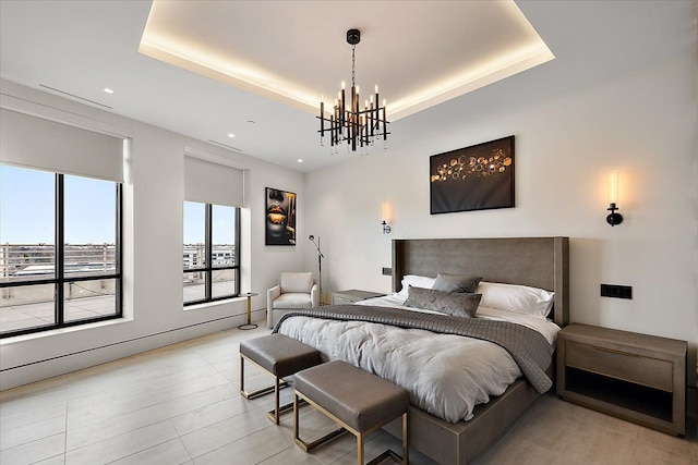 bedroom featuring a raised ceiling and a chandelier