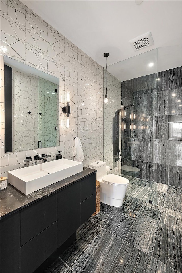 bathroom featuring visible vents, toilet, a walk in shower, and tile walls