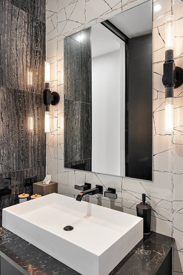 bathroom featuring tile walls and a sink