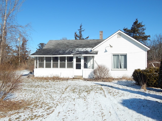 view of front of house featuring a sunroom and a chimney