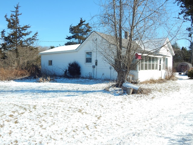 snow covered property featuring a sunroom