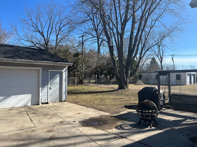 exterior space with a garage, an outbuilding, and fence