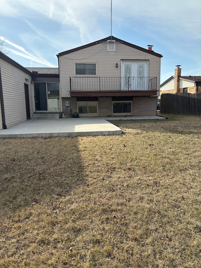 back of property with a patio, a yard, fence, and brick siding