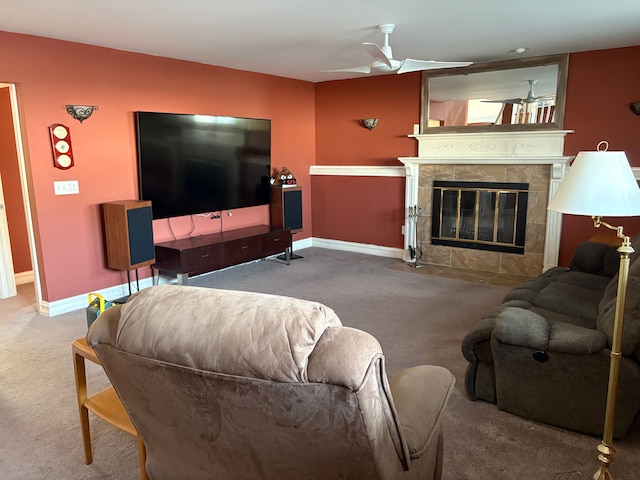 living area featuring a ceiling fan, baseboards, carpet floors, and a tile fireplace