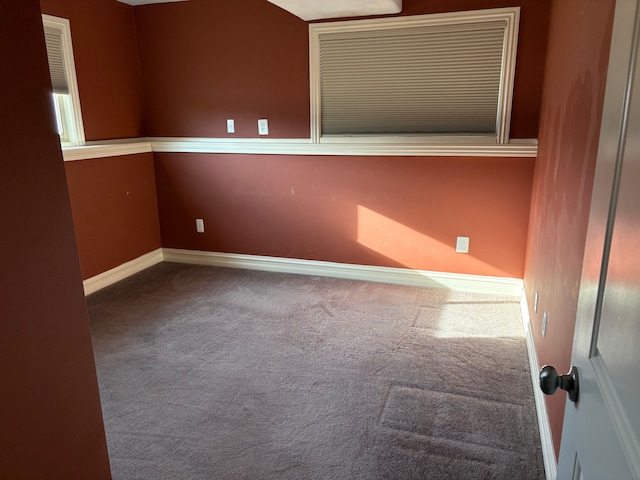 carpeted spare room featuring baseboards