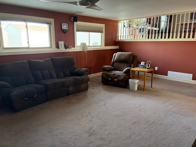 carpeted living room featuring visible vents, baseboards, and a ceiling fan