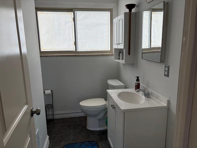 bathroom with baseboards, toilet, vanity, and tile patterned flooring