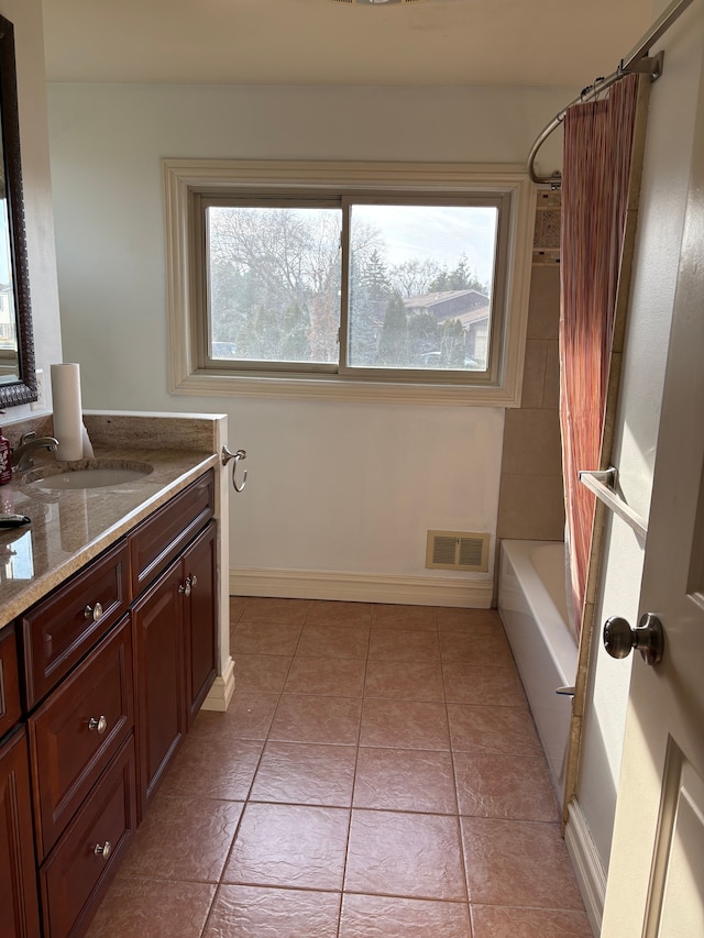 bathroom featuring tile patterned floors, visible vents, shower / bath combo, baseboards, and vanity