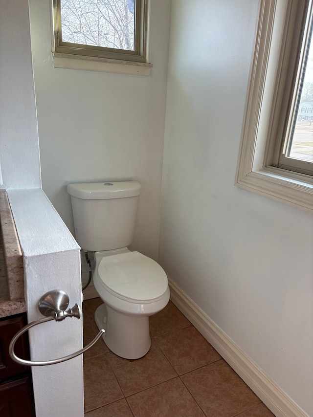 bathroom with tile patterned floors, toilet, and baseboards