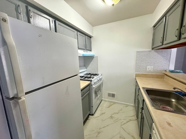 kitchen featuring marble finish floor, backsplash, a sink, white appliances, and under cabinet range hood