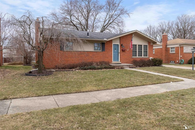 view of front facade featuring a front yard and brick siding