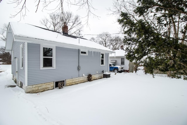 snow covered property with a chimney