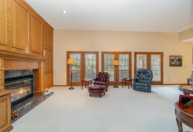 living area with a healthy amount of sunlight, carpet, a fireplace, and baseboards