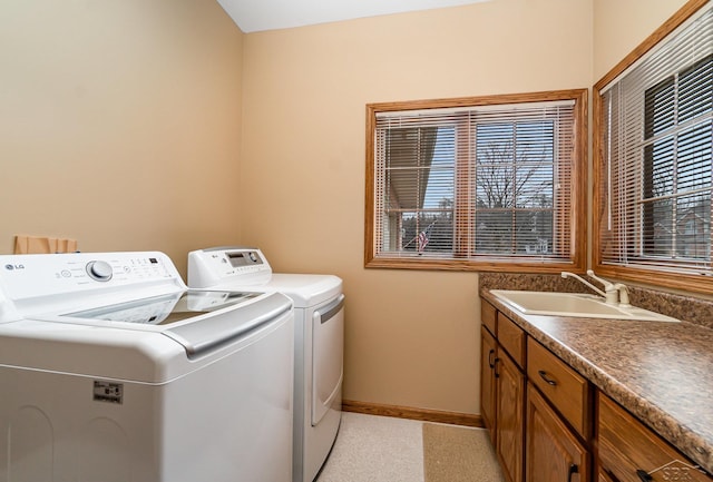 laundry room featuring independent washer and dryer, a sink, and baseboards