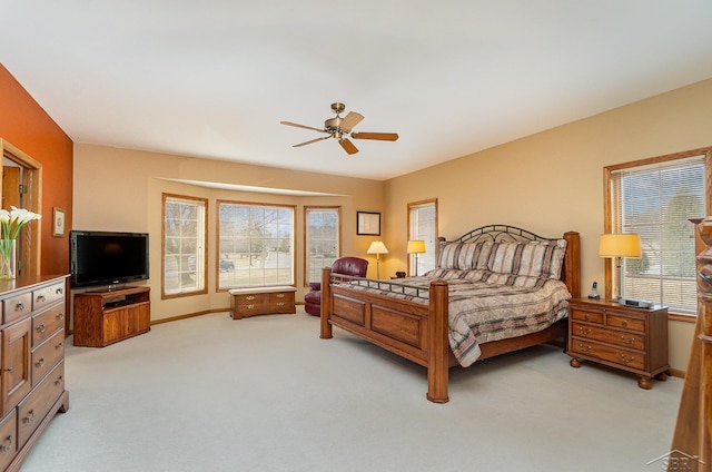 bedroom featuring ceiling fan, baseboards, and light colored carpet