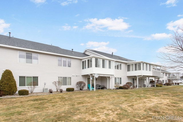 rear view of property with a sunroom and a yard