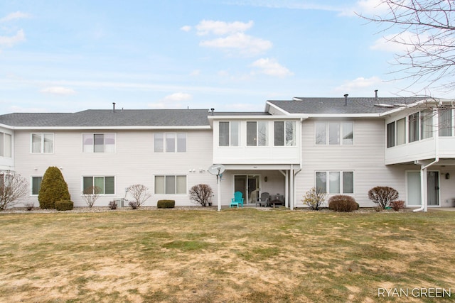 back of house featuring a sunroom and a lawn