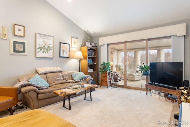 living area with light carpet and high vaulted ceiling