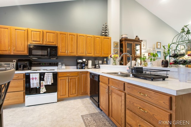 kitchen featuring a sink, black appliances, a peninsula, and light countertops