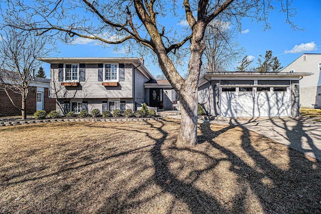 split level home with a garage, an outbuilding, and driveway