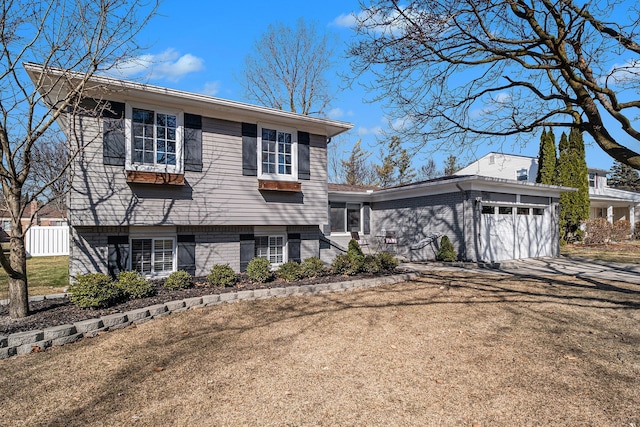 split level home featuring brick siding, driveway, and a garage