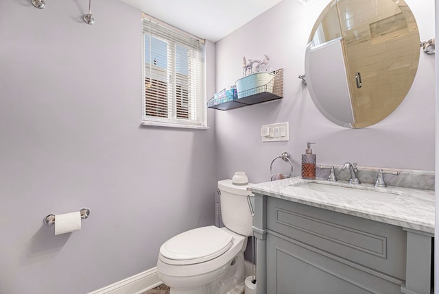 bathroom with an enclosed shower, baseboards, toilet, and vanity