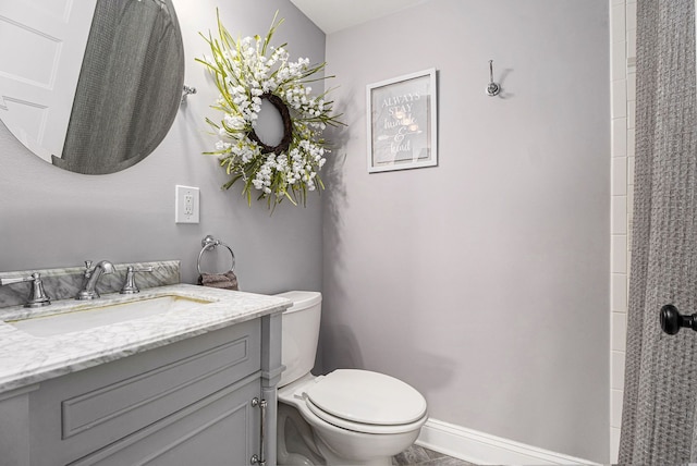 bathroom with vanity, toilet, and baseboards