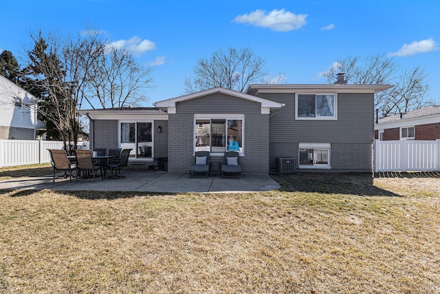 rear view of house featuring fence, a yard, central AC, a patio area, and brick siding