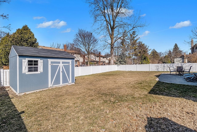 view of yard featuring a storage unit, a patio, an outbuilding, and a fenced backyard