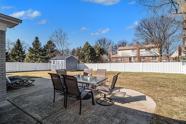 view of patio with outdoor dining area, a fenced backyard, an outdoor structure, and a shed