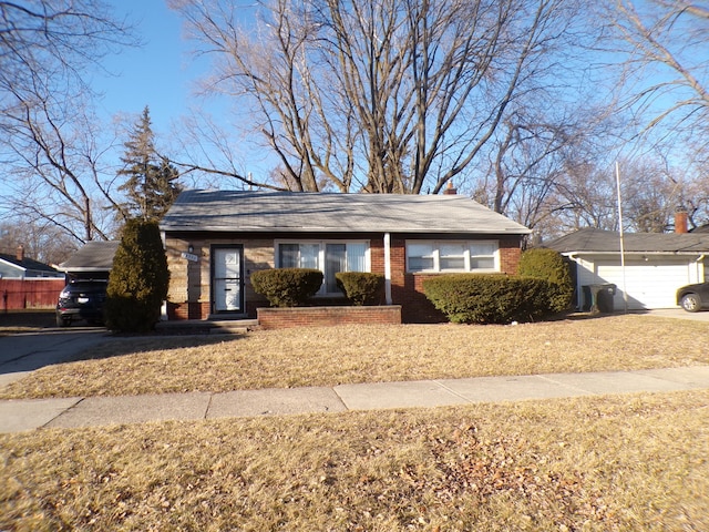 ranch-style house with a garage, an outbuilding, and brick siding