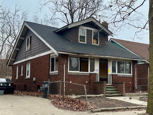 bungalow-style house featuring entry steps, brick siding, and a chimney