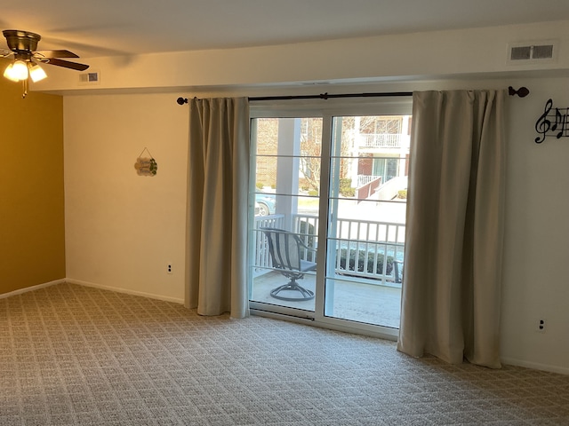 spare room with baseboards, carpet flooring, visible vents, and a ceiling fan