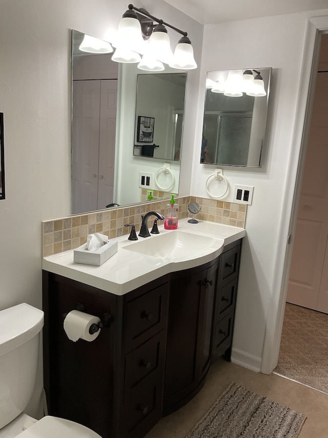 bathroom featuring vanity, backsplash, and toilet