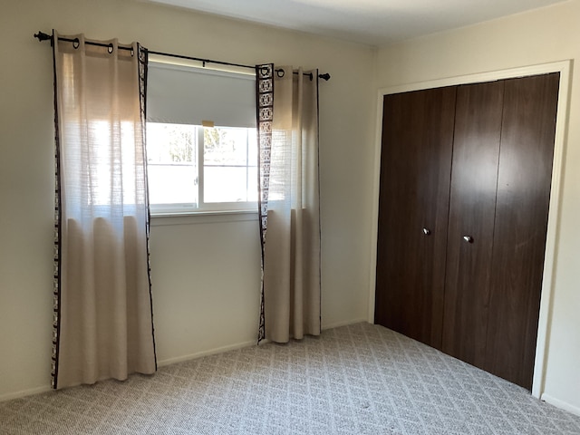 unfurnished bedroom featuring a closet and light colored carpet