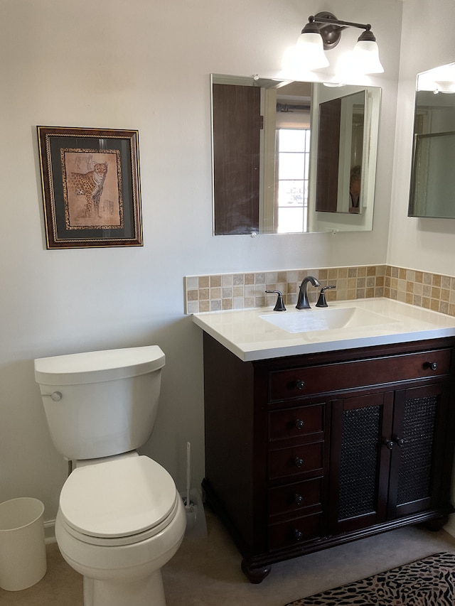 bathroom featuring toilet, tasteful backsplash, and vanity