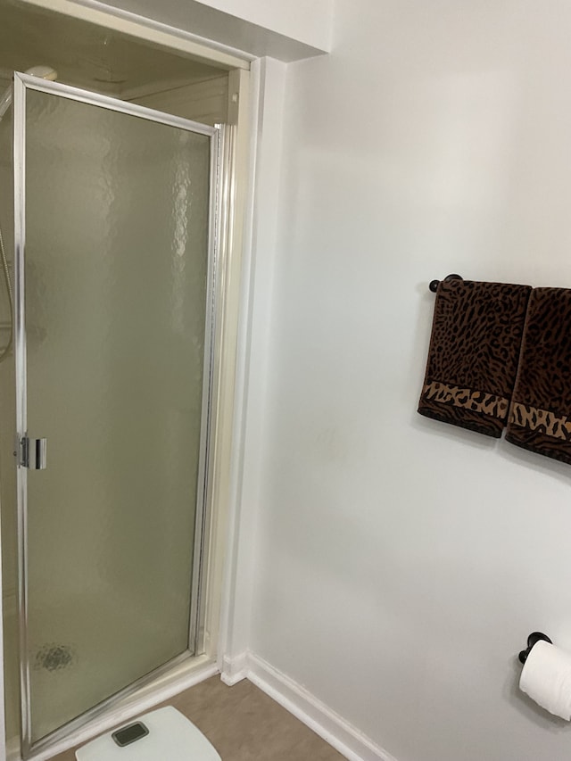 full bath with a stall shower and baseboards