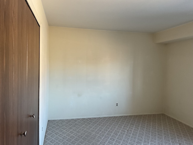 unfurnished room featuring carpet floors and baseboards