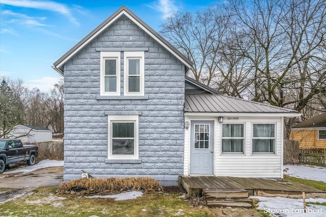 view of front of house with metal roof and fence