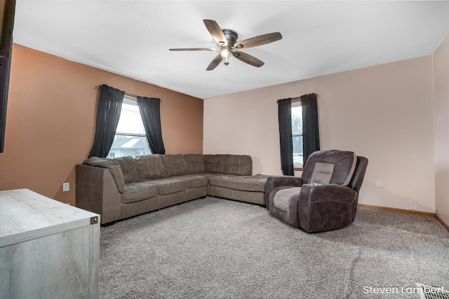 carpeted living room with a ceiling fan, plenty of natural light, and baseboards