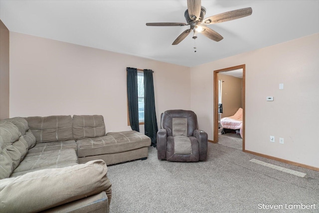 carpeted living room featuring ceiling fan and baseboards